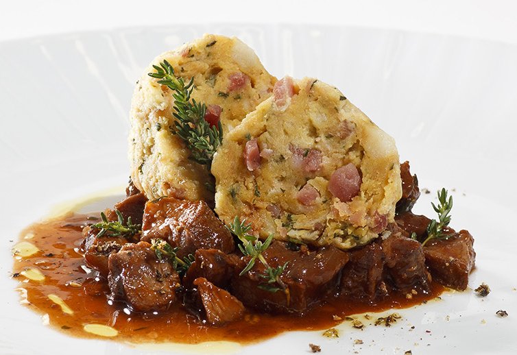 Speckknödel als Beilage zu Rindgulasch